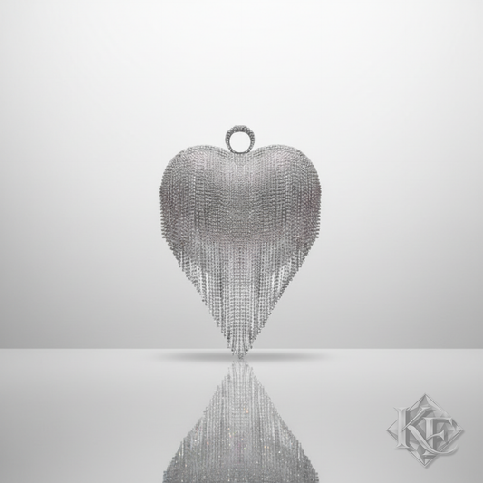 Silver heart-shaped pendant with fringe on a reflective surface