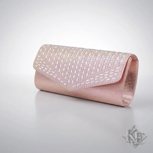 A light pink clutch purse featuring a textured, rhinestone-embellished flap and smooth pink leather sides, shown on a neutral gray background.