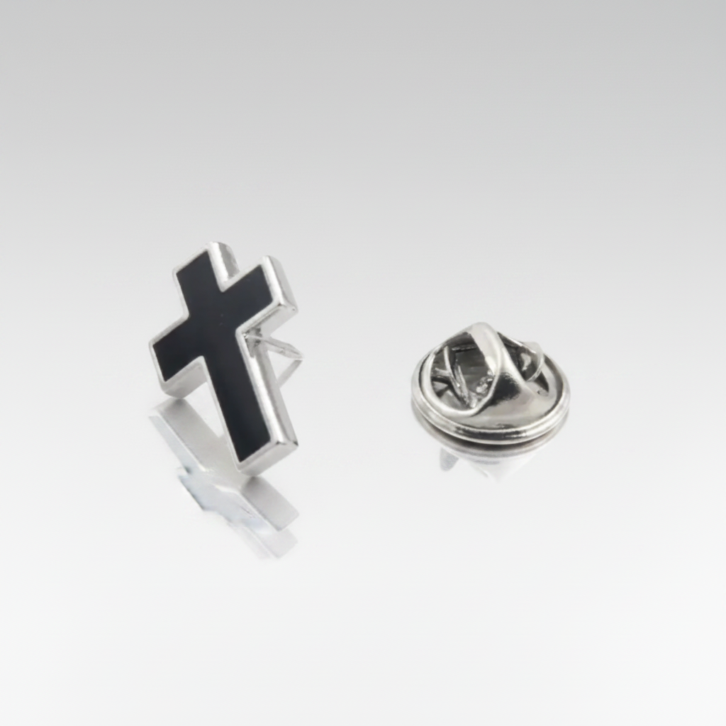 A black cross-shaped lapel pin with a silver tone edge, displayed against a white background.