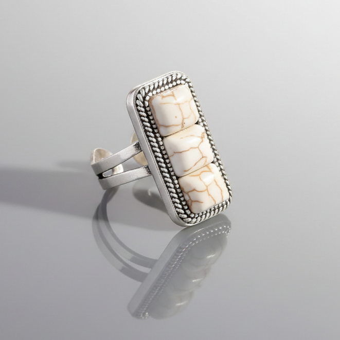 Silver ring with a rectangular stone on a gray background