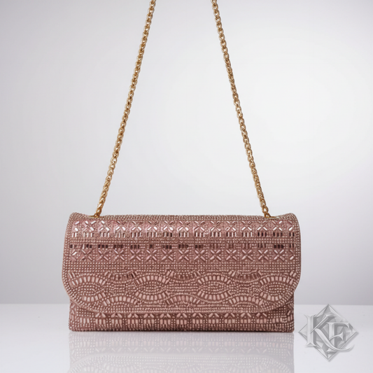 Rose gold clutch bag with chain strap on a white background