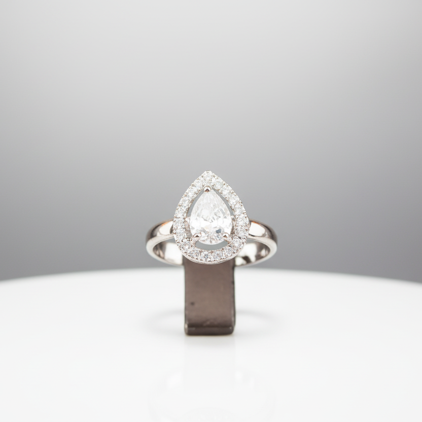 Pear-shaped diamond ring on a white stand with a gray background