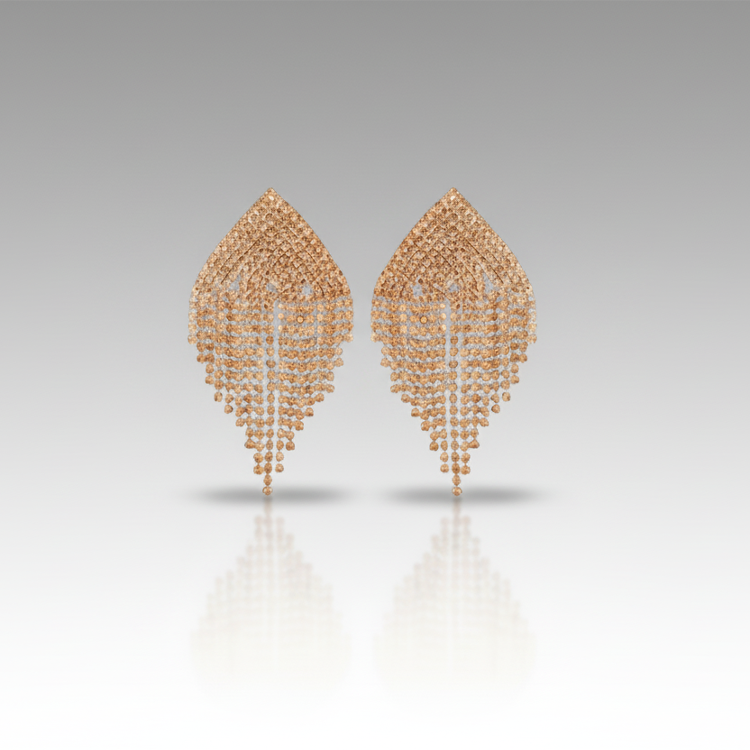 Pair of champagne gold earrings on a reflective surface with a gradient background