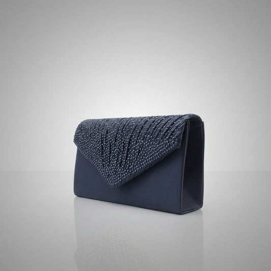 Navy blue clutch bag with studded detail on a gray background