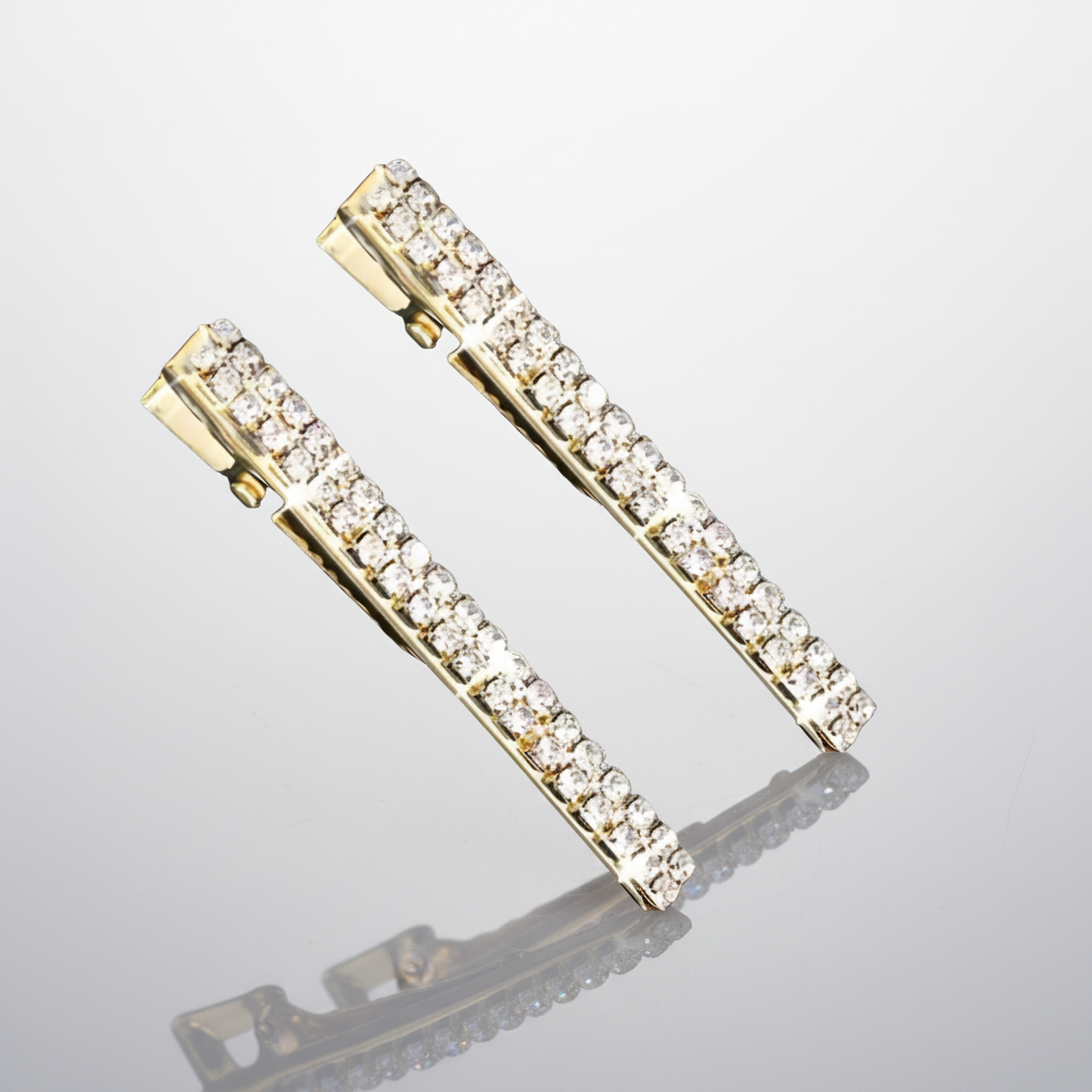 Gold hair clips with clear gemstones on a white background