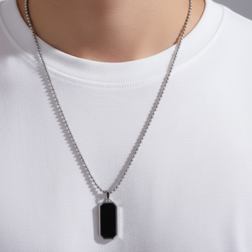 Mannequin wearing a white shirt with a silver necklace featuring a black pendant.