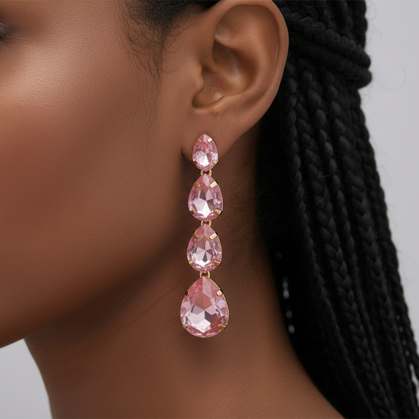 Close-up of a woman wearing pink teardrop earrings with a neutral background