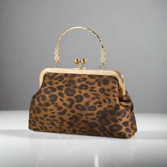 Leopard print handbag with gold frame and handle on a gray background