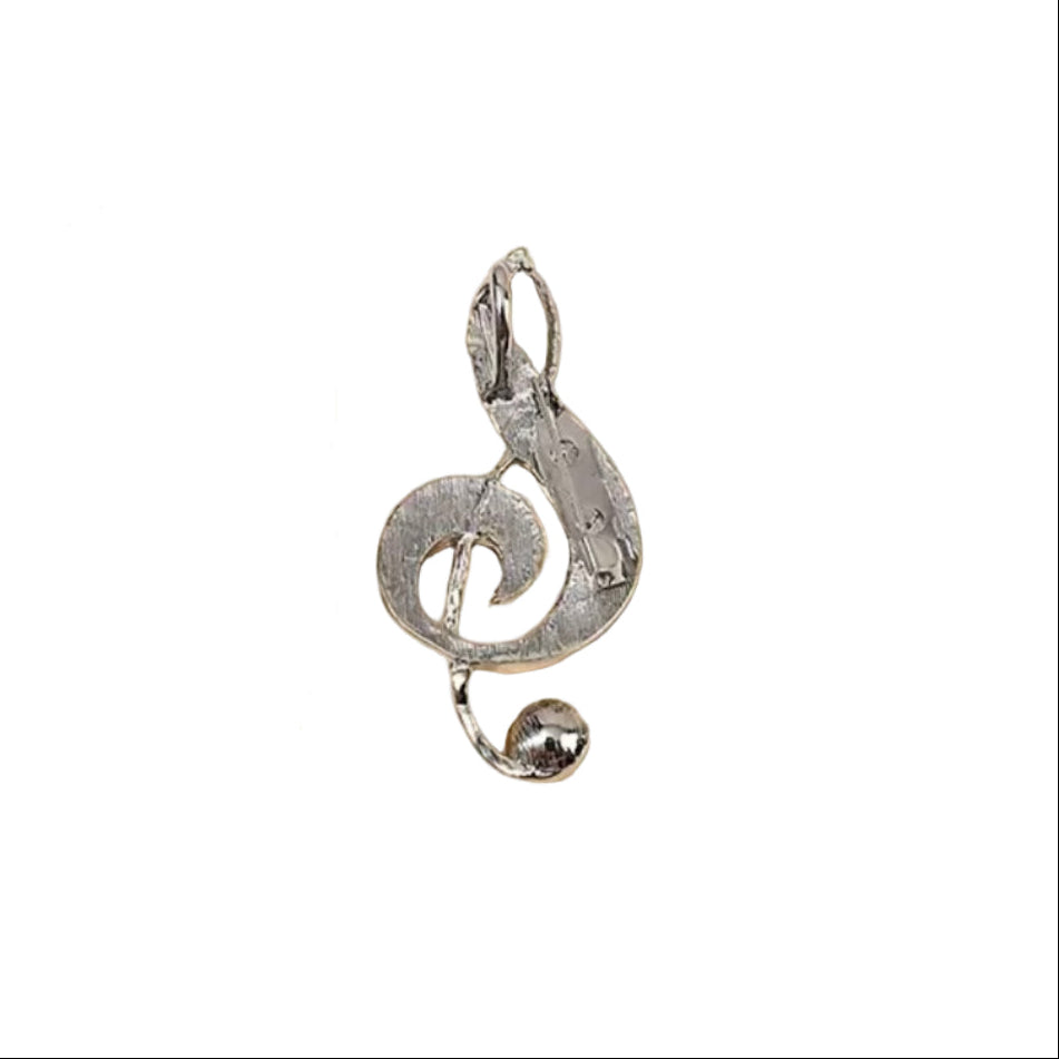 Backside of treble clef brooch on a white background