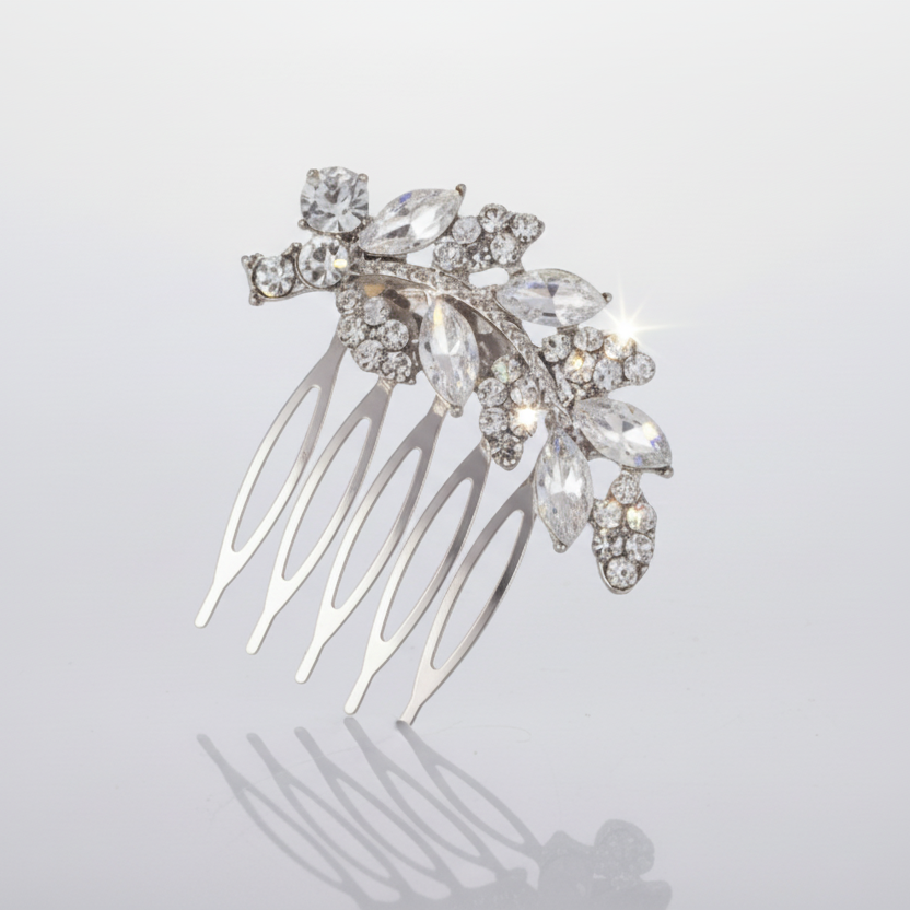 Silver hair comb with crystal leaves on a light gray background
