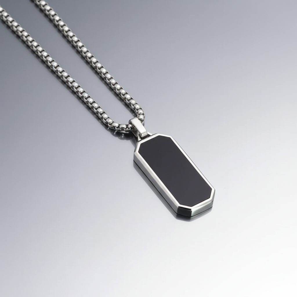 Silver necklace with a black pendant on a gradient gray background