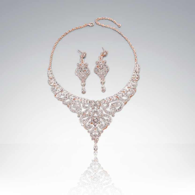 Rose gold necklace and earrings set on a light gray background