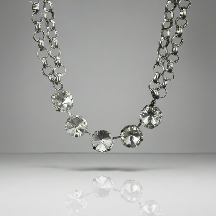 Silver necklace with clear stones on a gray background