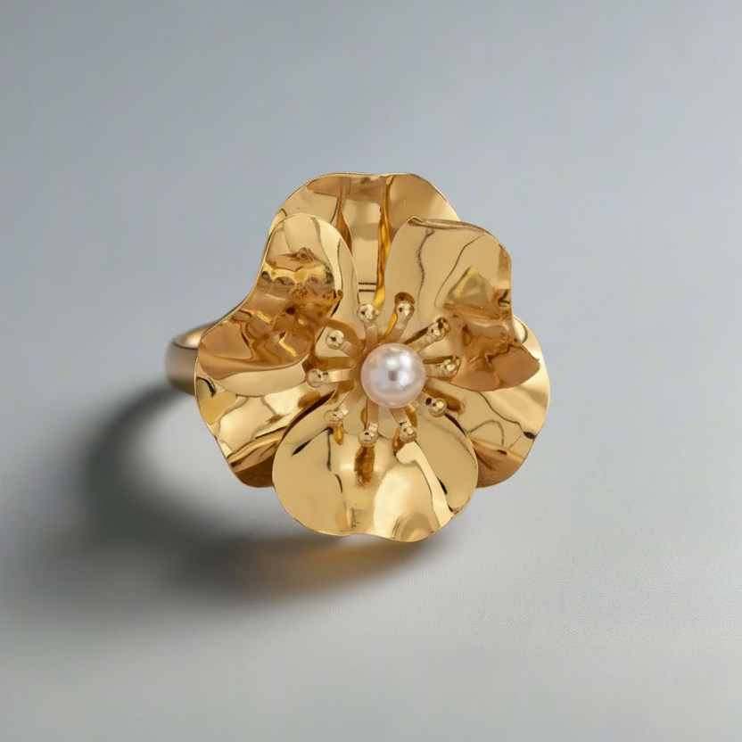 Gold ring with a pearl center on a gray background