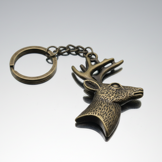 A vintage gold tone deer keychain made of copper, with a loop on top for easy attachment.
