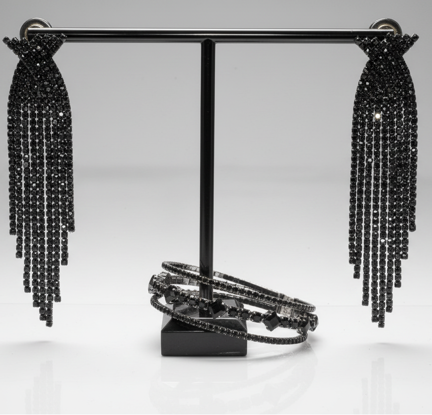Black beaded earrings on a stand with a gray background