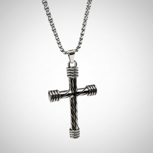 Silver cross pendant on a chain against a light gray background