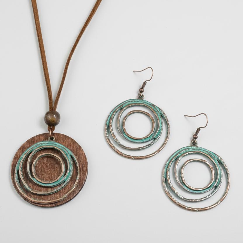 A set of bohemian jewelry featuring a bronze and wood theme, including a long necklace with a circular pendant and a pair of earrings.