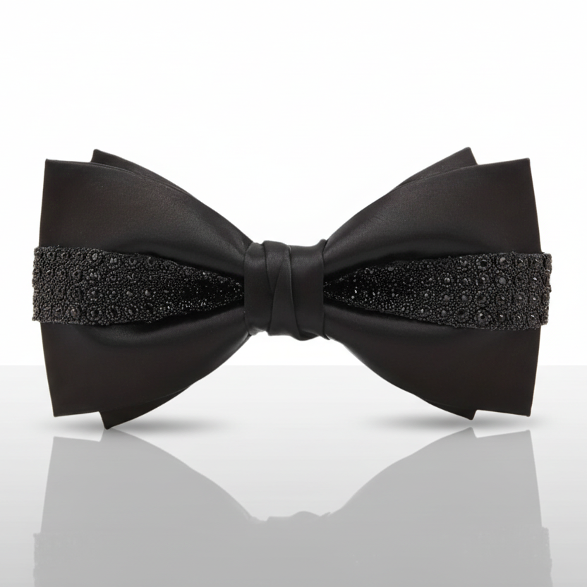 Black bow tie with decorative elements on a reflective surface