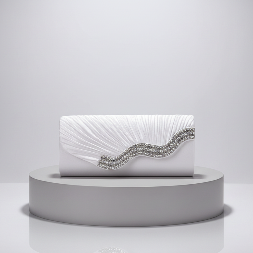 White clutch bag with decorative elements on a gray platform against a light gray background