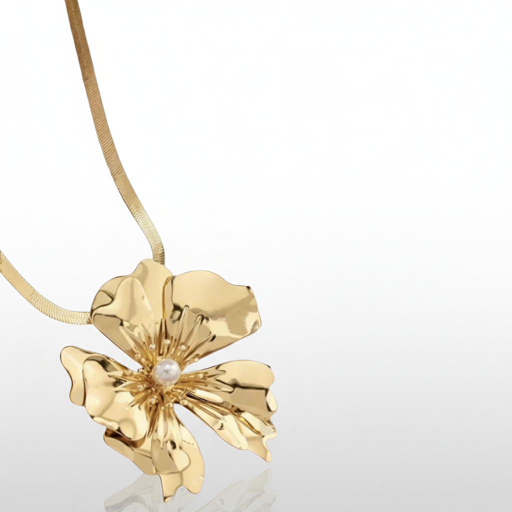 Gold flower-shaped necklace with a pearl on a white background