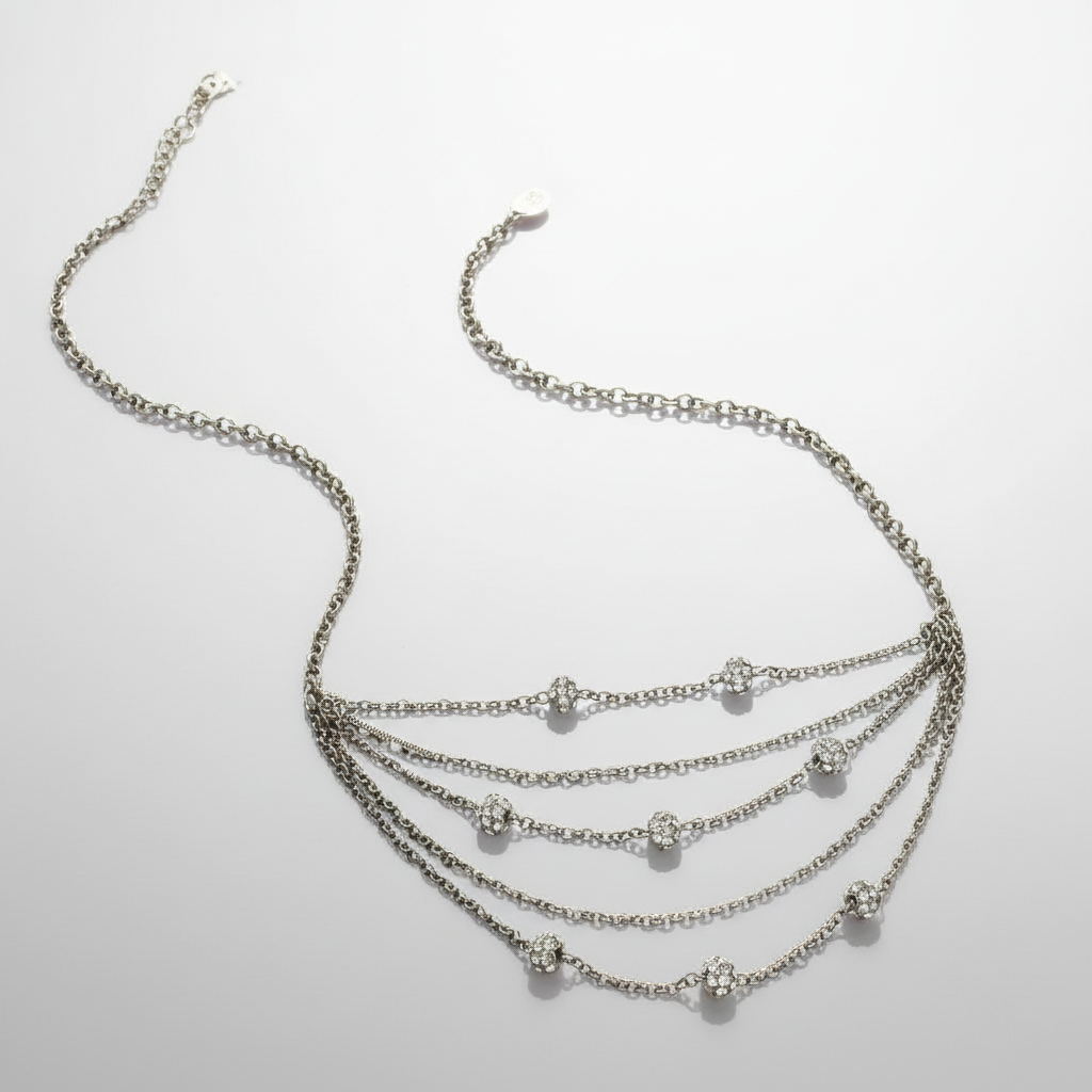 Multi-layered silver necklace on a light gray background