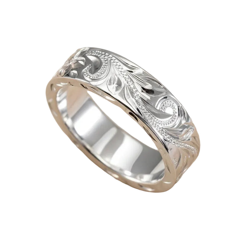 Silver ring with intricate designs on a light background