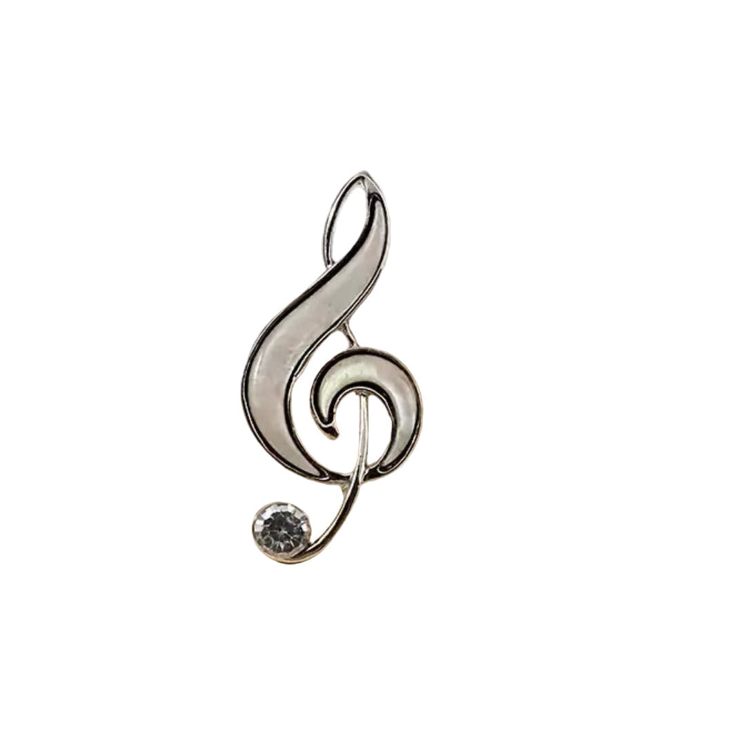 Silver treble clef brooch pin accented with a clear stone on a white background