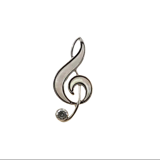 Silver treble clef brooch pin accented with a clear stone on a white background