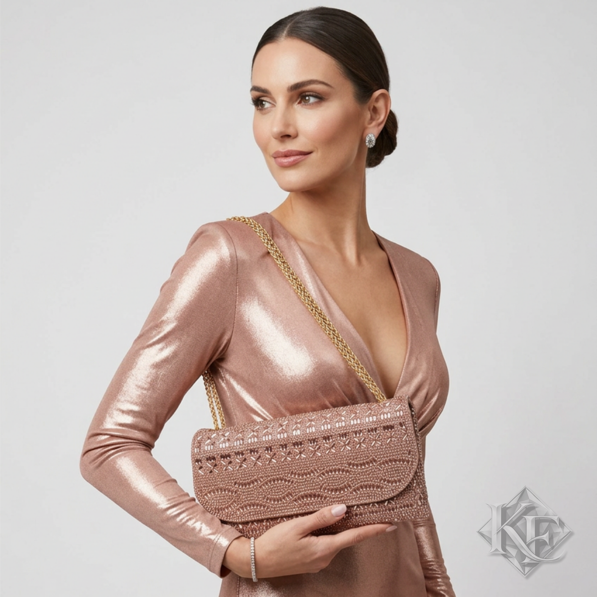 A woman wearing a metallic rose gold long-sleeve dress holds a matching metallic rose gold clutch bag with a gold chain strap against a light gray studio background.