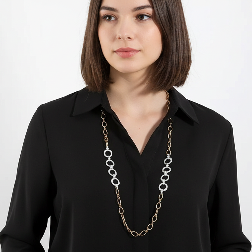 Woman wearing a long chain necklace against a white background