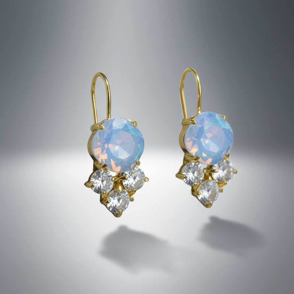 Pair of gold earrings with blue gemstones and clear stones on a gray background