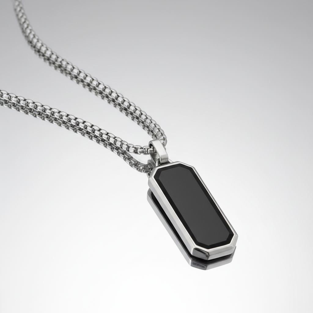 Silver necklace with a black pendant on a light gray background