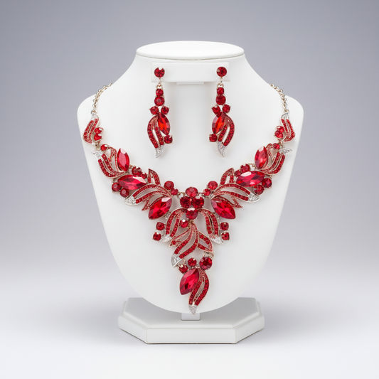 Red jewelry set with necklace and earrings on a white stand against a gray background