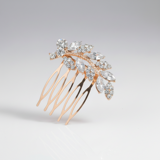 Gold hair comb with crystal leaves on a light gray background