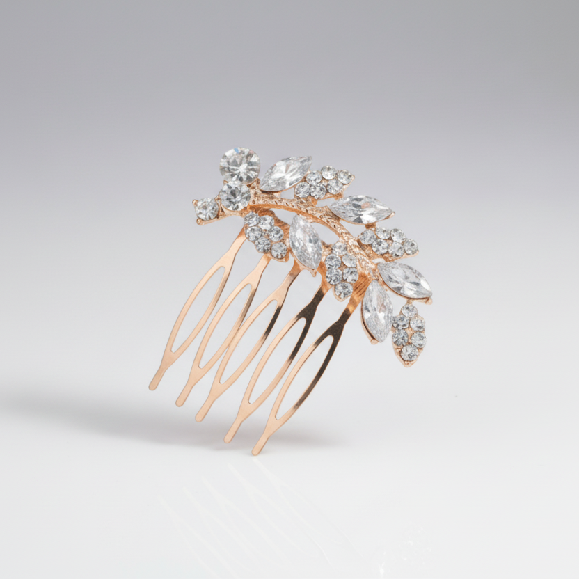 Gold hair comb with crystal embellishments on a light gray background