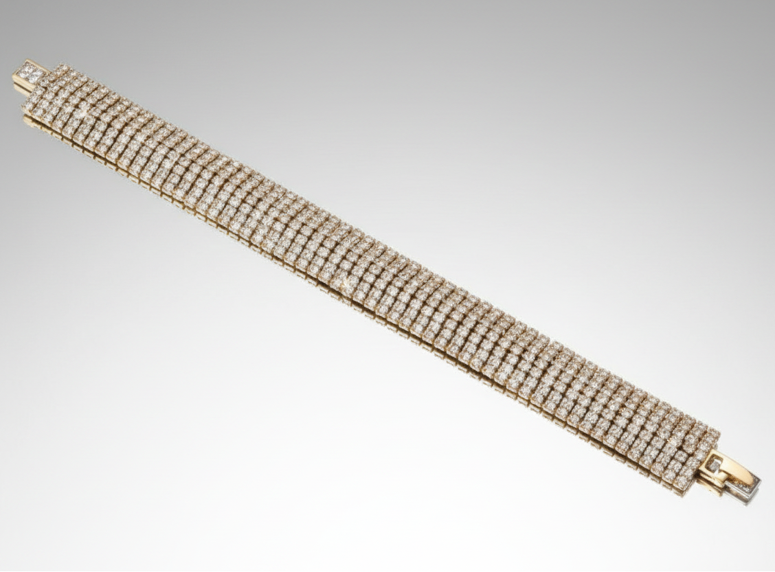 Gold bracelet with clear gemstones on a gray background