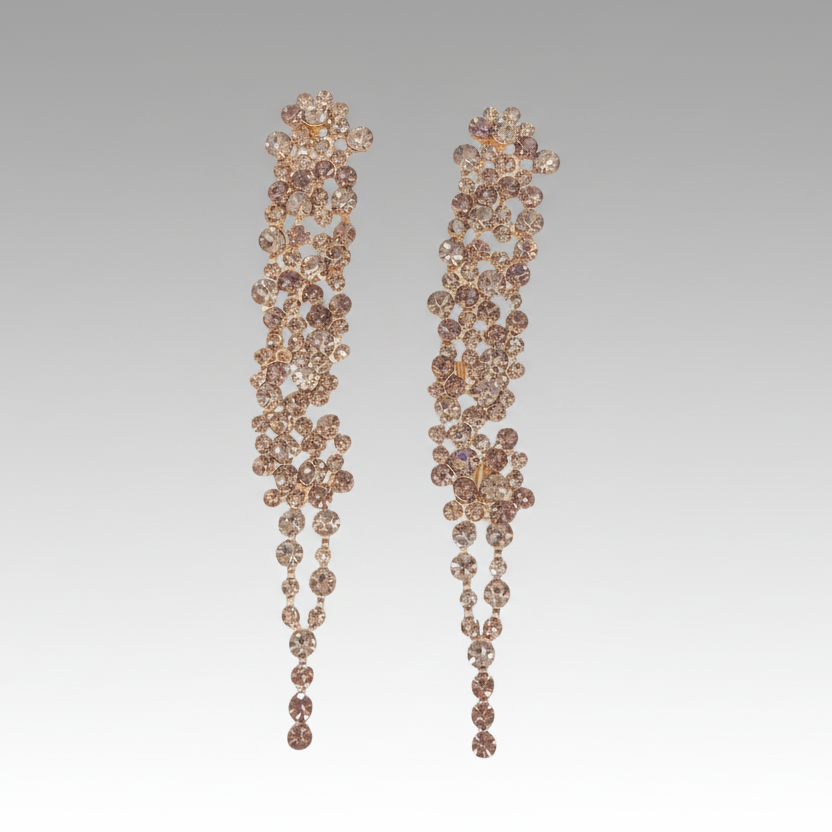Pair of long, ornate earrings with floral designs on a white background