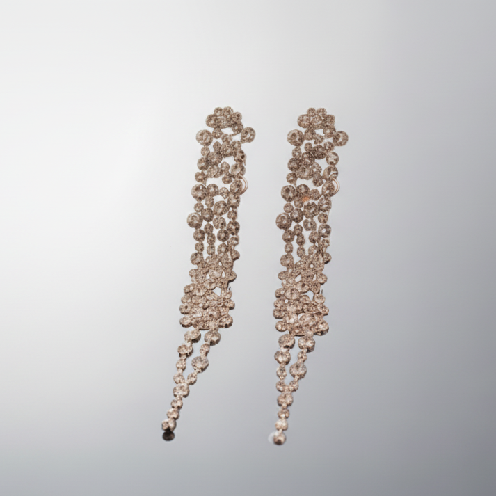 Pair of dangling earrings on a reflective gray surface