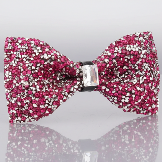 A pink bowtie adorned with red rhinestones and a crystal embellishment in the center.