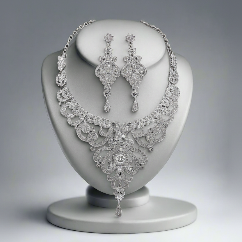 Diamond necklace and earrings on a gray stand against a gray background
