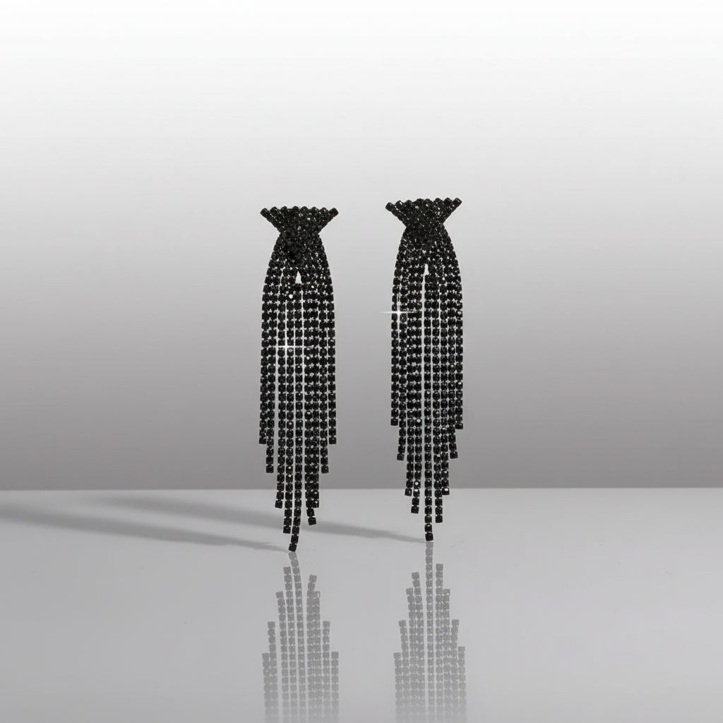Pair of black beaded earrings on a reflective surface with a gradient background