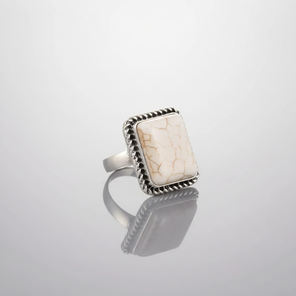 Silver ring with a square stone on a light gray background