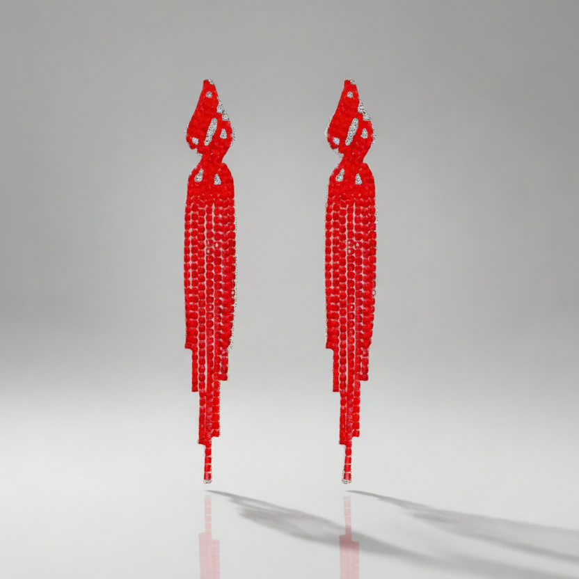 Pair of red tassel earrings on a light gray background