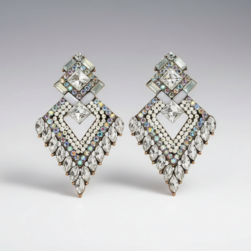 Pair of ornate earrings with multicolored gemstones on a gray background