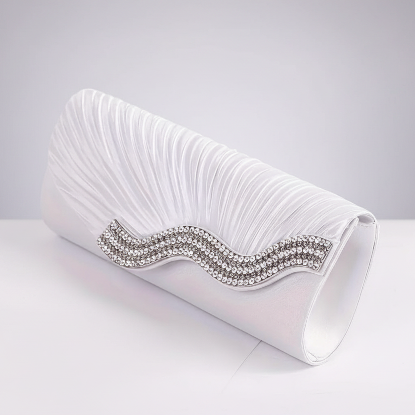 White clutch bag with a decorative wave pattern and rhinestone details on a lght gray background
