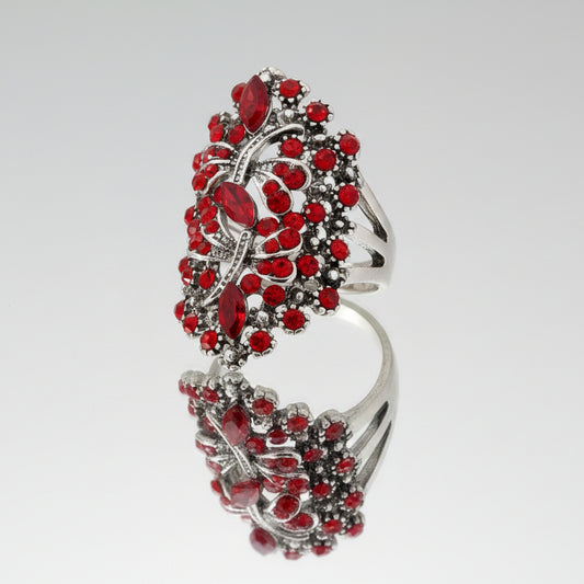 Silver ring with red gemstones on a white background