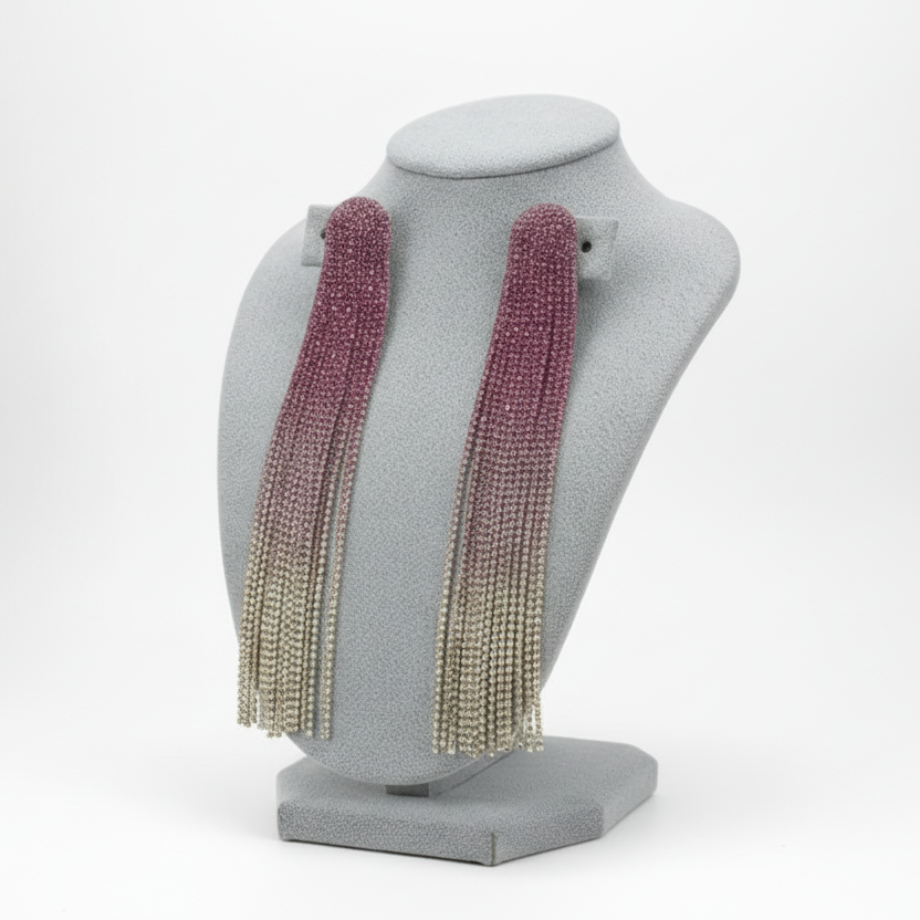 Purple and gold fringe earrings on a gray bust against a dark background
