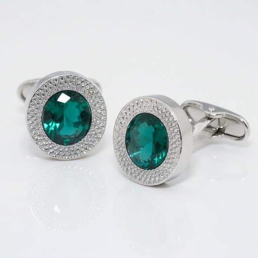 Silver cufflinks with green gemstones on a white background