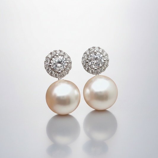 Pearl earrings with diamond-like tops on a light gray background